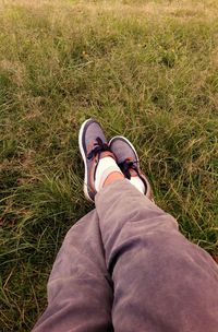 Low section of man standing on grass