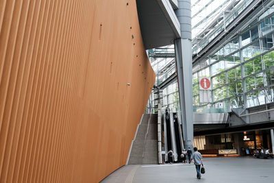 People walking by building in city