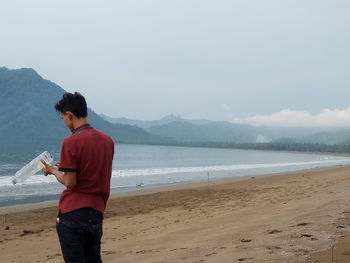 Man standing on beach against sky