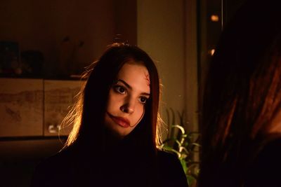 Close-up of young woman with halloween make-up in darkroom