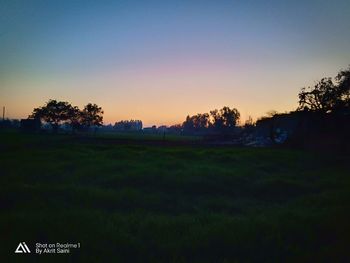 Scenic view of field against clear sky during sunset