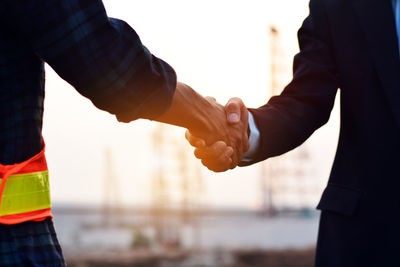 Midsection of couple holding hands