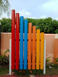 Row of multi colored umbrellas on field against sky