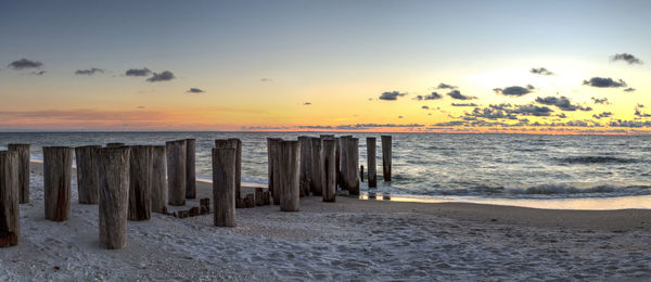 Dilapidated ruins of a pier on port royal beach at sunset in naples, florida