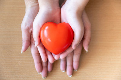 Midsection of woman holding red heart