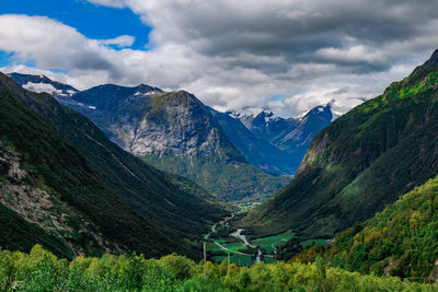 View from the road on a the valley between beautiful norwegian mountains against dramatic cloudy sky