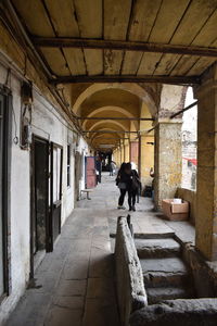 Rear view of man walking in corridor of building