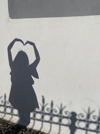 Shadow of woman standing against wall