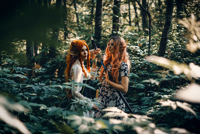 Rear view of woman sitting in forest