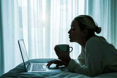 Side view of young woman using mobile phone