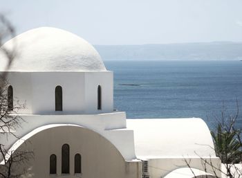 White building by sea against sky