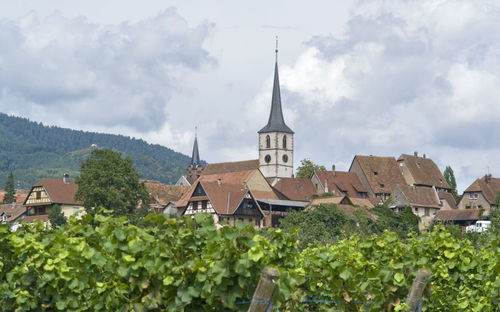 Panoramic view of buildings and trees against sky