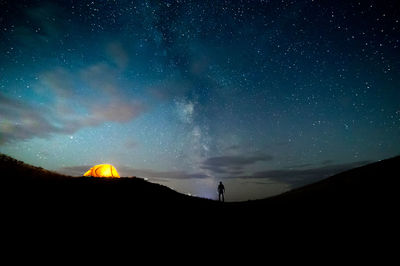 Scenic view of silhouette mountains against sky at night