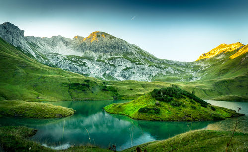 Scenic view of lake and mountains against sky