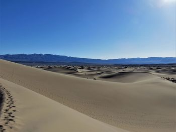 Scenic view of desert against clear blue sky