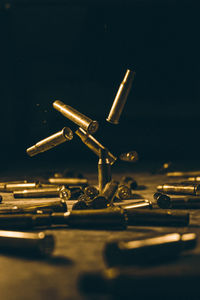 Close-up of bullet shells on table against black background