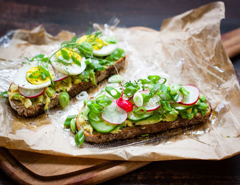 High angle view of open faced sandwiches on wax paper