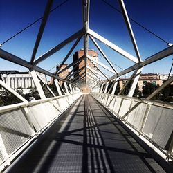 View of footbridge against clear blue sky