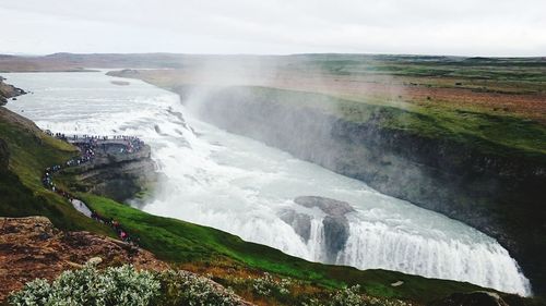 Scenic view of waterfall against sky