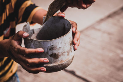 Cropped hand giving currency to male beggar on footpath