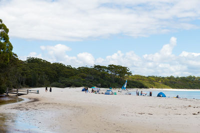 Group of people on beach against sky