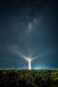 Scenic view of illuminated field against sky at night