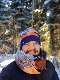 Portrait of a smiling young man standing against the background of trees