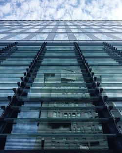 Low angle view of modern building against cloudy sky