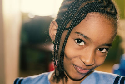 Close-up portrait of smiling girl with braided hair