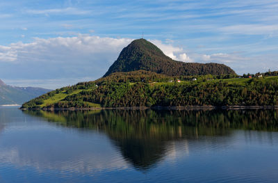 Scenic view of lake by mountain against sky