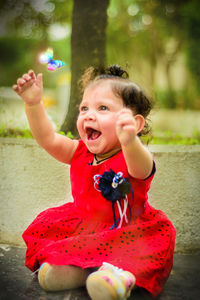 Portrait of a smiling girl sitting outdoors