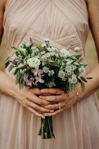 Midsection of woman holding flower bouquet