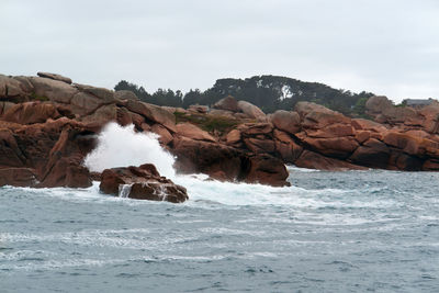 Scenic view of rocks in sea against sky