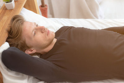 Midsection of young woman sleeping on bed