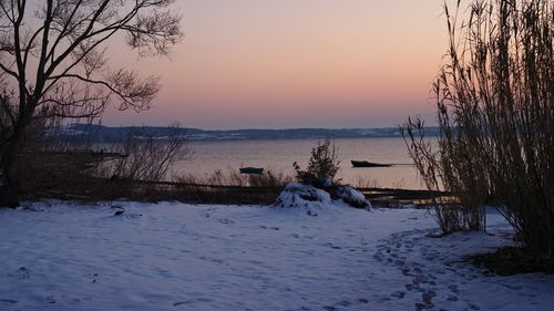 Scenic view of frozen lake against sky during sunset