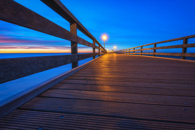 Bridge over calm sea at sunset