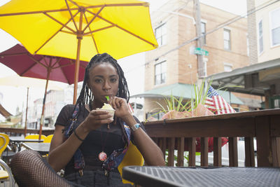 A young woman eating frozen yoghurt.