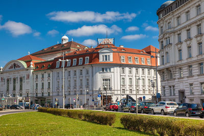 Buildings by road against sky in city