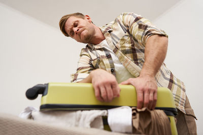 Side view of senior man sitting on sofa at home