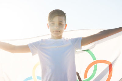 Portrait of boy holding flag while standing outdoors