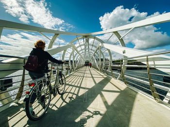 People on bridge against sky