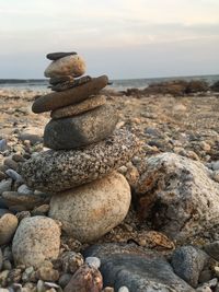 Stack of pebbles on beach against sky