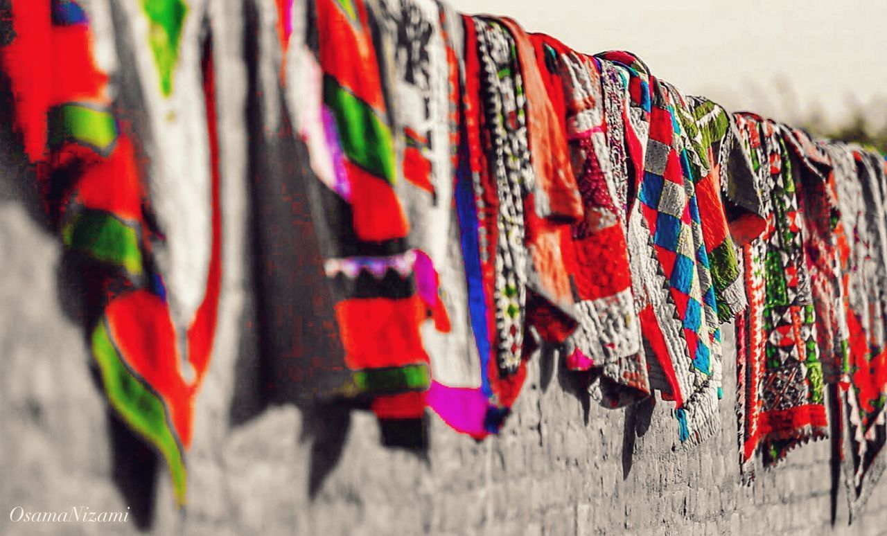 CLOSE-UP OF CLOTHES HANGING AGAINST WALL