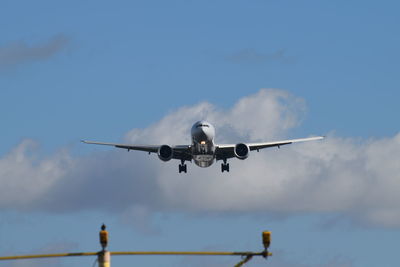 Low angle view of airplane flying against sky