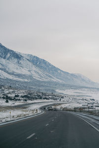 Road leading towards mountains against sky