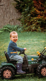 Happy boy sitting on toy tractor