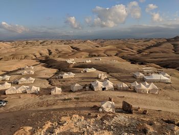 Houses on arid landscape against sky