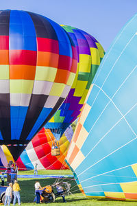 People inflating hot air balloon on field