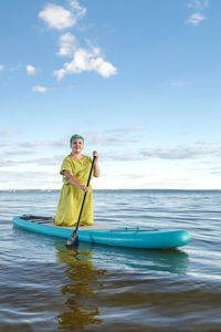 Rear view of woman swimming in sea against sky