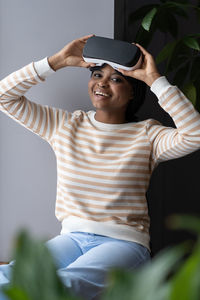 Happy african female hold vr headset for simulation in augmented reality test modern gadget at home